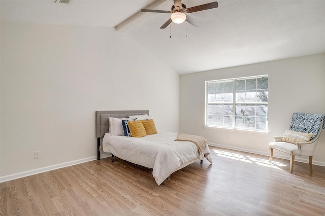 bedroom featuring ceiling fan, light hardwood / wood-style flooring, and lofted ceiling with beams