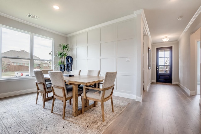 dining room featuring light wood-type flooring and ornamental molding