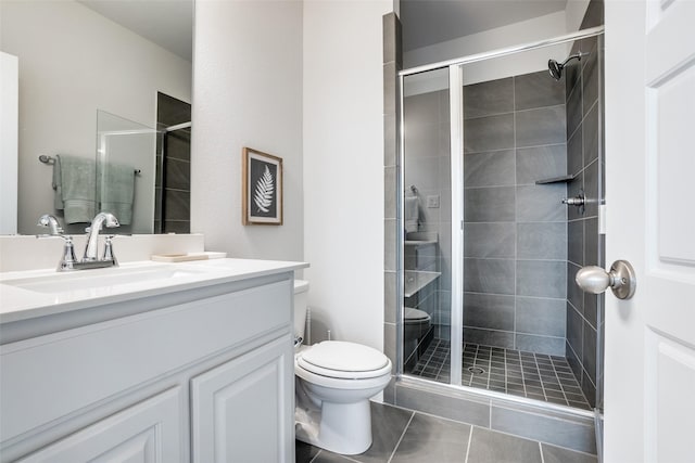 bathroom with toilet, tile patterned flooring, walk in shower, and vanity