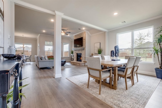 dining space featuring a wealth of natural light, crown molding, and light hardwood / wood-style flooring