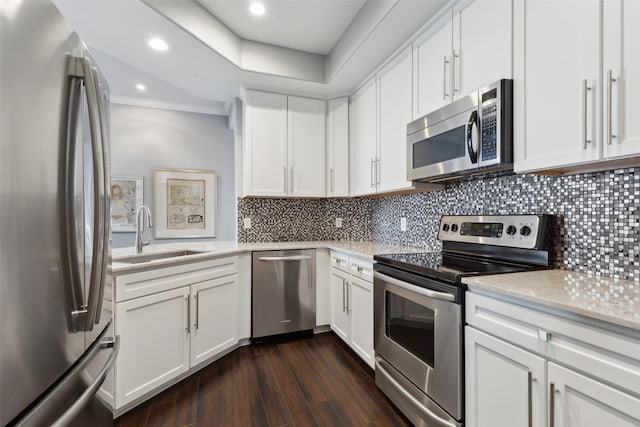 kitchen featuring stainless steel appliances, sink, white cabinets, tasteful backsplash, and dark wood-type flooring