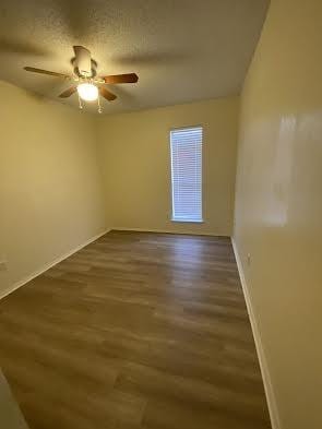 unfurnished room featuring ceiling fan, a textured ceiling, and dark hardwood / wood-style floors