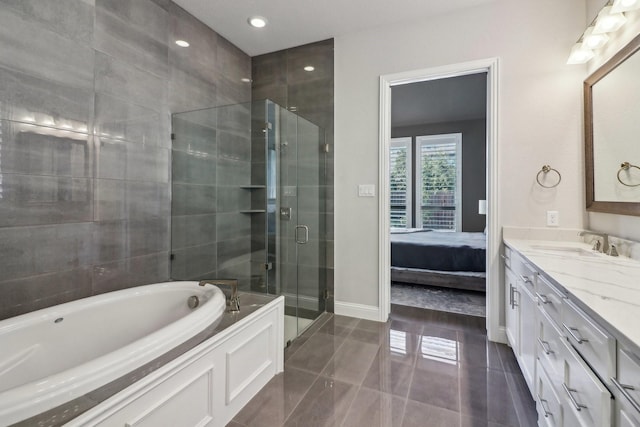 ensuite bathroom featuring a stall shower, vanity, a bath, baseboards, and tile patterned floors