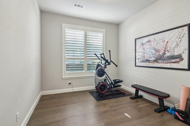 workout room with baseboards, visible vents, and wood finished floors