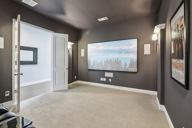 carpeted home theater room featuring visible vents and baseboards