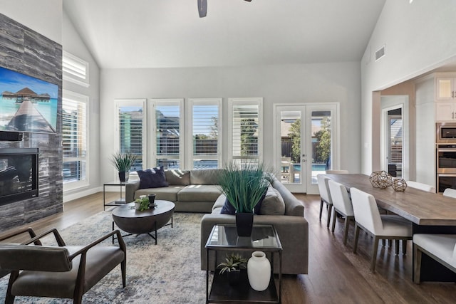 living room with visible vents, wood finished floors, french doors, a fireplace, and high vaulted ceiling