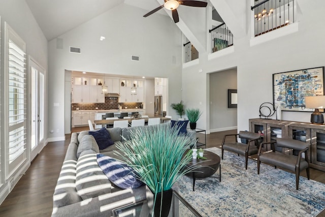 living area with ceiling fan, dark wood-style flooring, visible vents, and baseboards