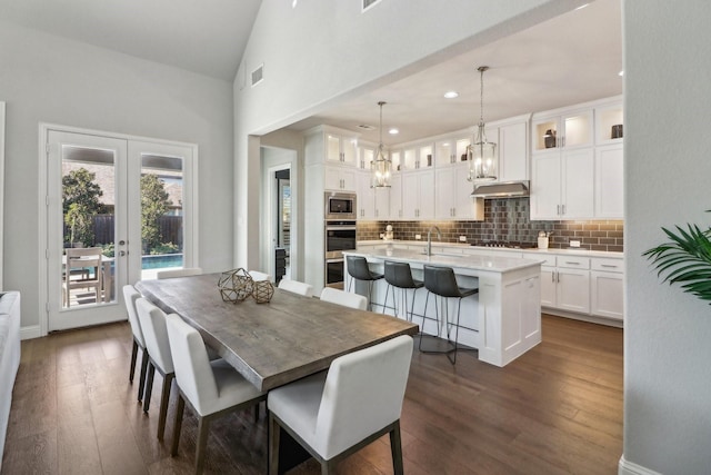 dining space with high vaulted ceiling, french doors, visible vents, and dark wood finished floors