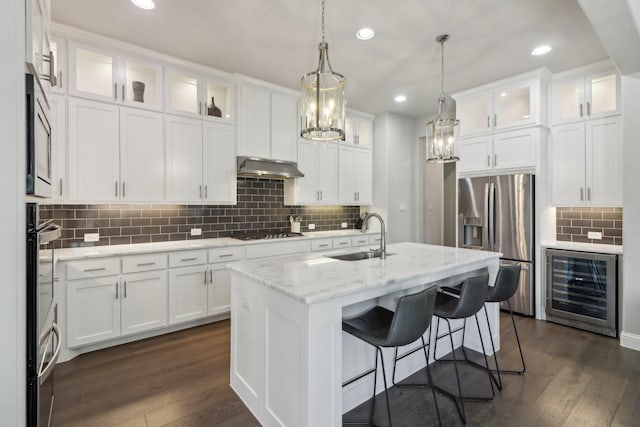 kitchen featuring wine cooler, stainless steel refrigerator with ice dispenser, a sink, gas cooktop, and under cabinet range hood