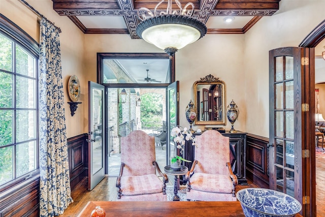 sitting room with french doors, ceiling fan, wood-type flooring, coffered ceiling, and crown molding