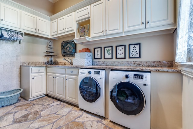 washroom featuring independent washer and dryer, cabinets, and sink