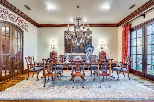 dining area with french doors, an inviting chandelier, and hardwood / wood-style floors