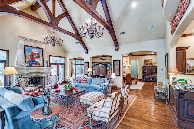 living room featuring a premium fireplace, high vaulted ceiling, ceiling fan with notable chandelier, and dark wood-type flooring