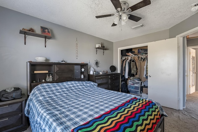 carpeted bedroom with a textured ceiling, ceiling fan, and a closet