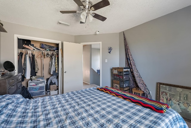 bedroom featuring a textured ceiling, ceiling fan, a closet, and carpet