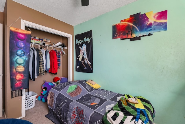 carpeted bedroom featuring a closet, ceiling fan, and a textured ceiling