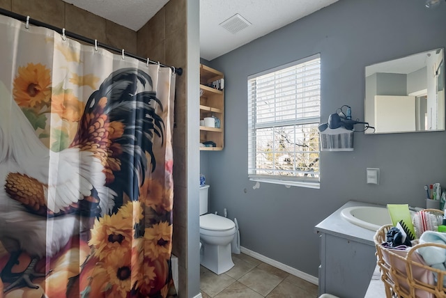 bathroom with toilet, a textured ceiling, tile patterned floors, and vanity