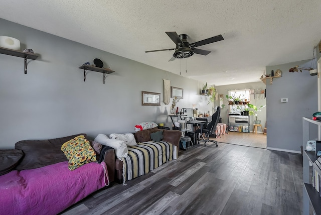 living room with a textured ceiling, ceiling fan, and wood-type flooring