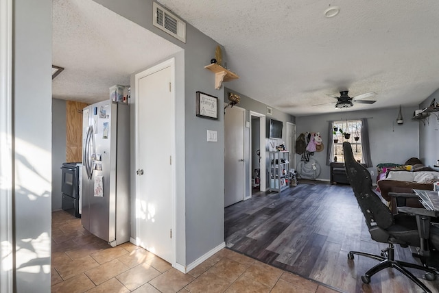 office with ceiling fan, tile patterned flooring, and a textured ceiling