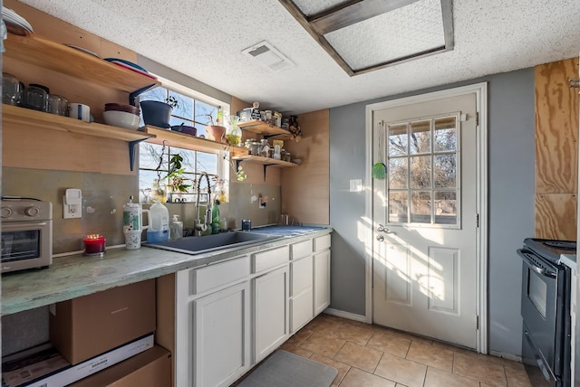 kitchen featuring sink, white cabinetry, a healthy amount of sunlight, and black range with electric cooktop