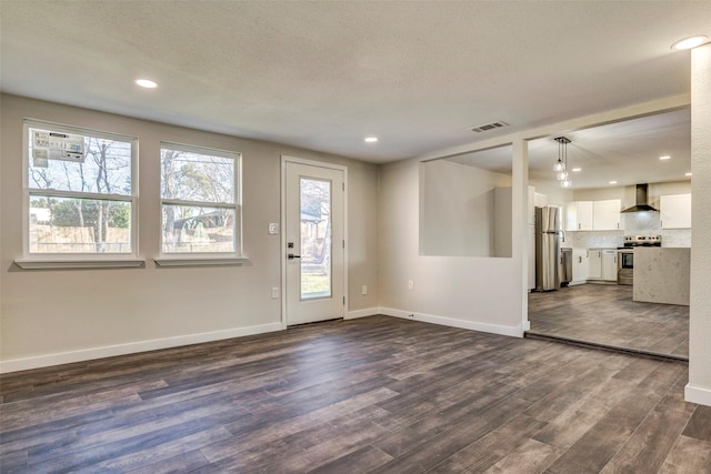 interior space with a textured ceiling and dark hardwood / wood-style flooring