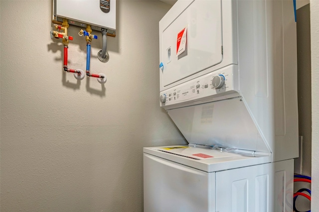 washroom featuring stacked washer and dryer and water heater