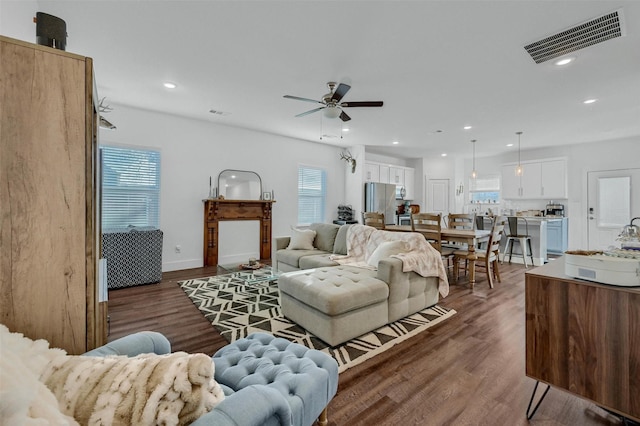 living room featuring dark hardwood / wood-style floors and ceiling fan