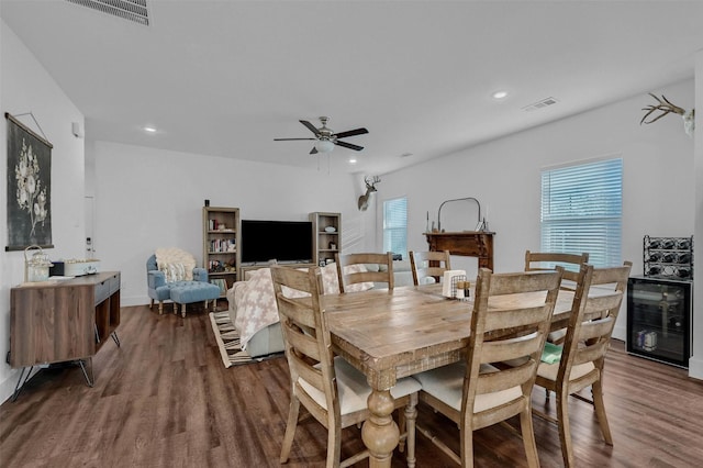 dining area with dark hardwood / wood-style floors, beverage cooler, and ceiling fan