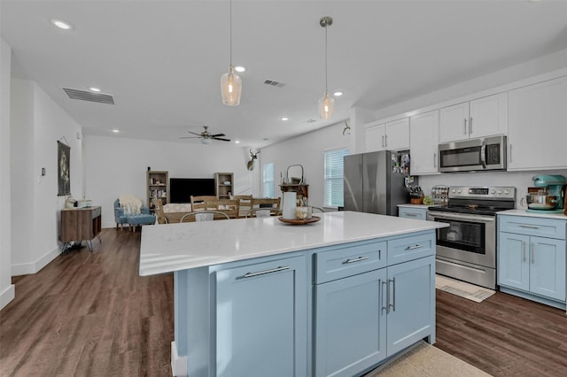 kitchen with a kitchen island, appliances with stainless steel finishes, decorative light fixtures, white cabinets, and ceiling fan