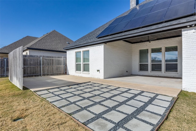 exterior space featuring solar panels, a patio, ceiling fan, and a lawn