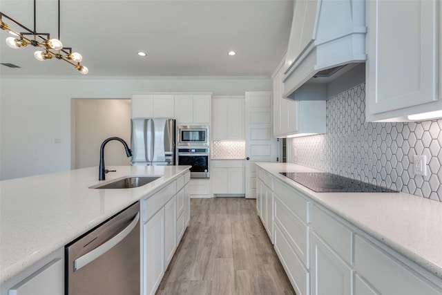 kitchen with appliances with stainless steel finishes, white cabinets, backsplash, and sink