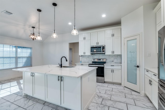 kitchen with stainless steel appliances, white cabinetry, an island with sink, and sink