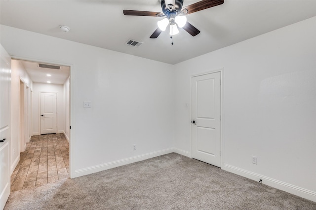 carpeted spare room featuring ceiling fan