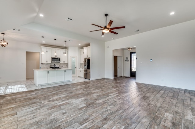 unfurnished living room featuring ceiling fan