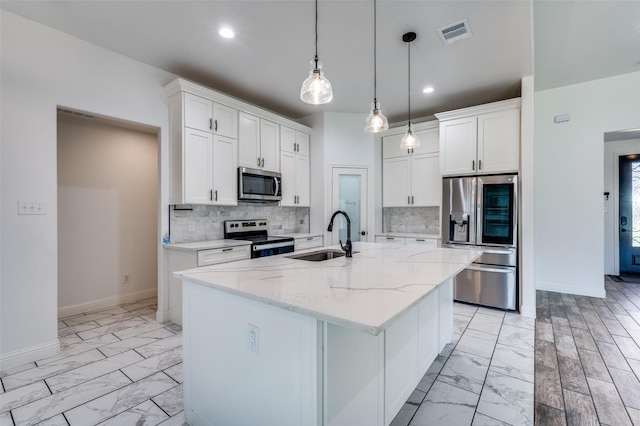 kitchen featuring sink, white cabinetry, light stone countertops, a kitchen island with sink, and appliances with stainless steel finishes