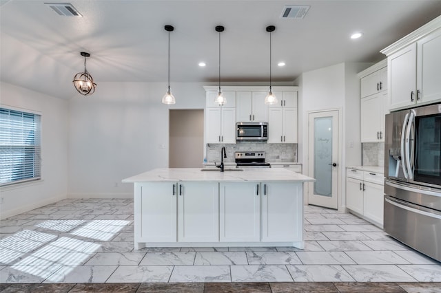 kitchen featuring white cabinets, a kitchen island with sink, pendant lighting, and appliances with stainless steel finishes