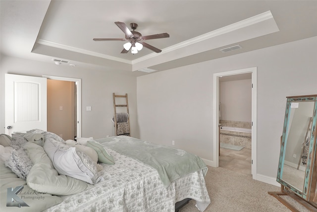 carpeted bedroom featuring ceiling fan, crown molding, a raised ceiling, and ensuite bath