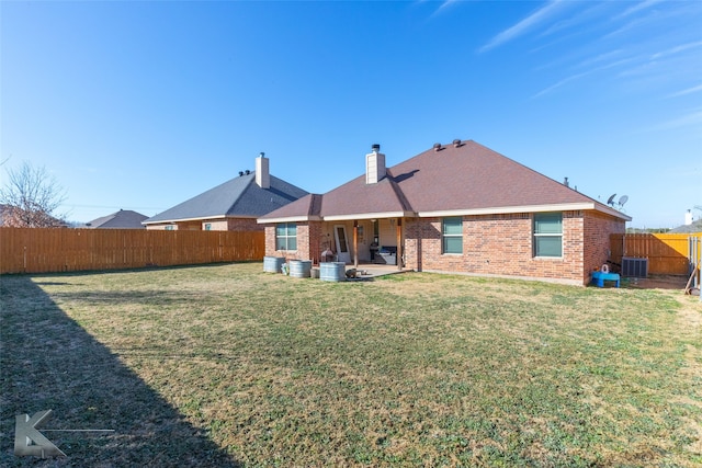 back of property with a lawn, central air condition unit, and a patio area