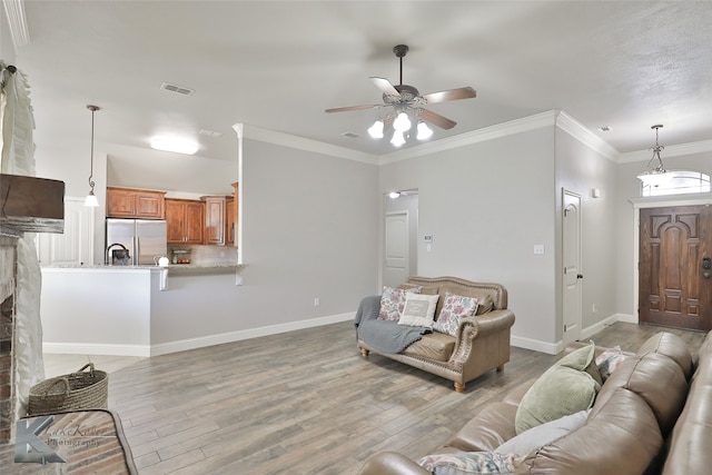 living room with ornamental molding, hardwood / wood-style flooring, and ceiling fan