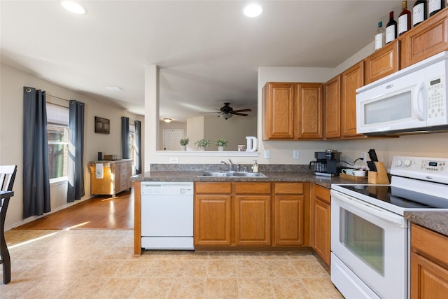 kitchen with white appliances, ceiling fan, kitchen peninsula, and sink