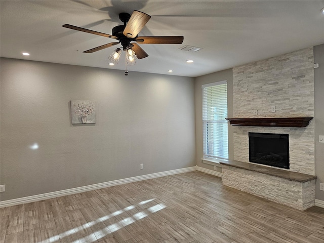 unfurnished living room featuring ceiling fan, a fireplace, and light hardwood / wood-style floors