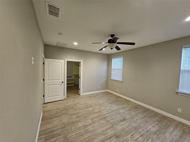 empty room with ceiling fan and light hardwood / wood-style flooring