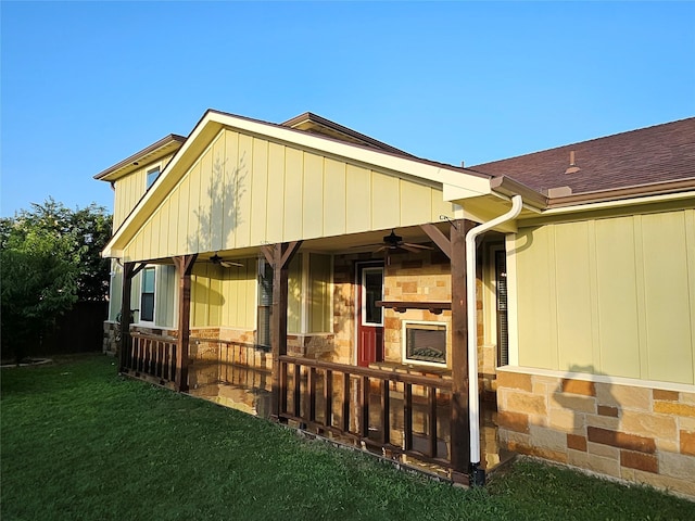 exterior space with ceiling fan and a yard