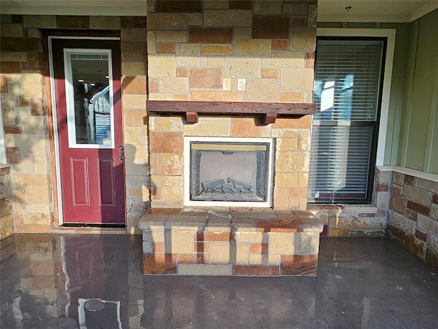 view of exterior entry with a stone fireplace