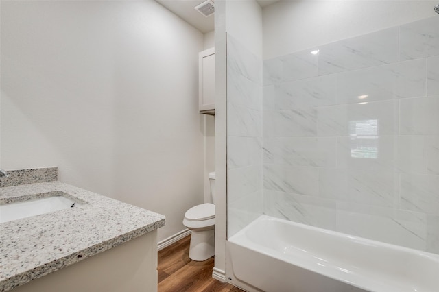 full bathroom with tiled shower / bath combo, wood-type flooring, vanity, and toilet