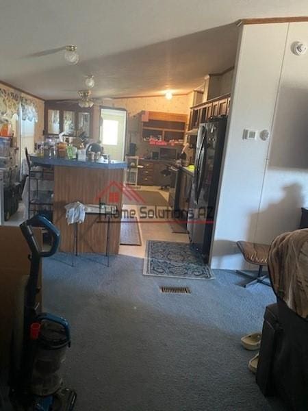 kitchen with ceiling fan, carpet floors, and stainless steel refrigerator