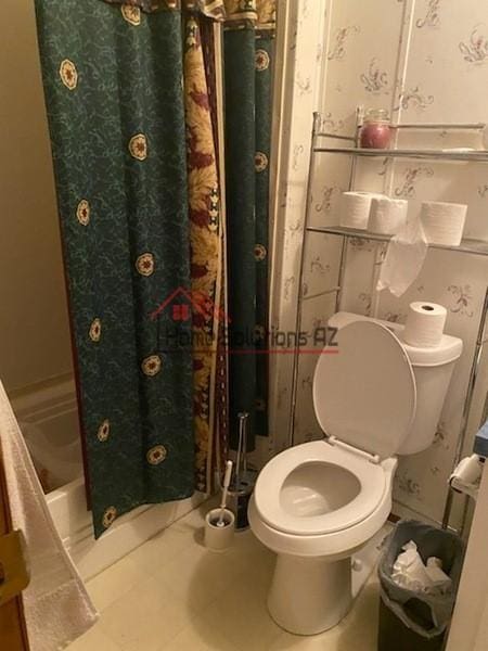 bathroom featuring shower / bath combo and toilet