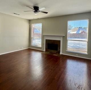 unfurnished living room with dark hardwood / wood-style flooring and ceiling fan