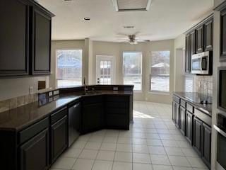 kitchen with sink, stainless steel appliances, ceiling fan, and light tile patterned floors