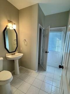 bathroom with toilet and tile patterned flooring